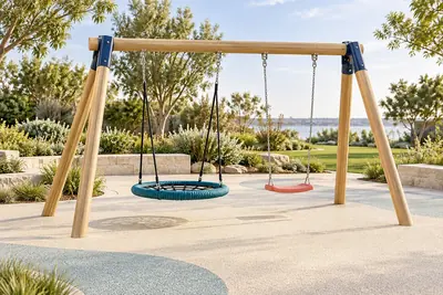 AI concept visual: a standalone playground swing frame in a bright landscaped park, sturdy timber A-frame, one teal nest swing and one coral flat swing, unobstructed view of suspension chains and.